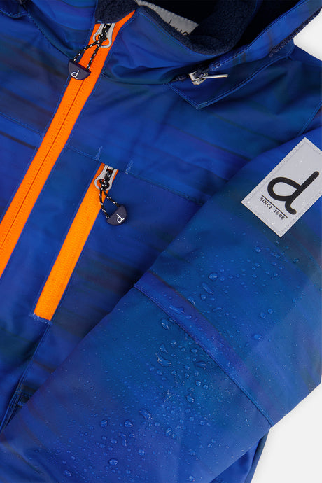 Close-up of the blue PLAY jacket with orange zipper and logo patch