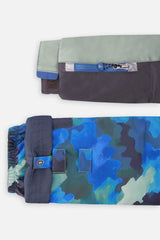Close-up of the PLAY jacket sleeve ski-pass pocket and the adjustable camouflage pant hem