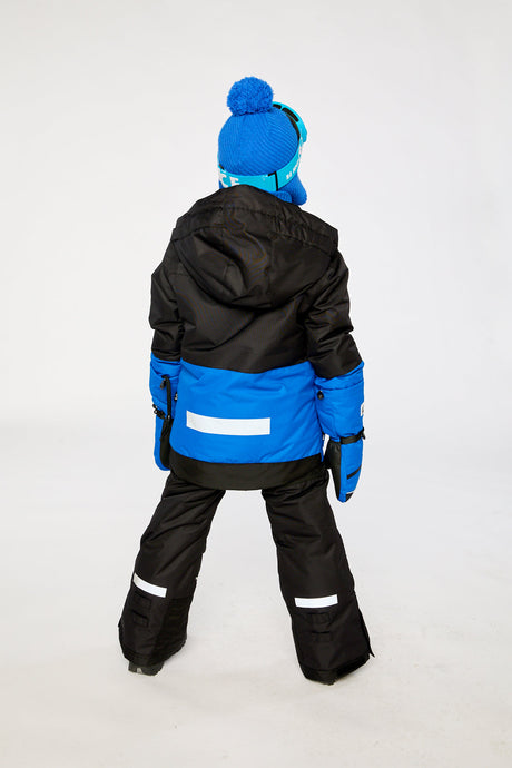 Child in the royal blue and red Deux par Deux TEKNIK two-piece snowsuit, third lookbook shot