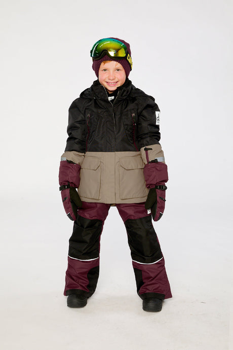 Child wearing the black, beige and burgundy Deux par Deux TEKNIK snowsuit, lookbook view