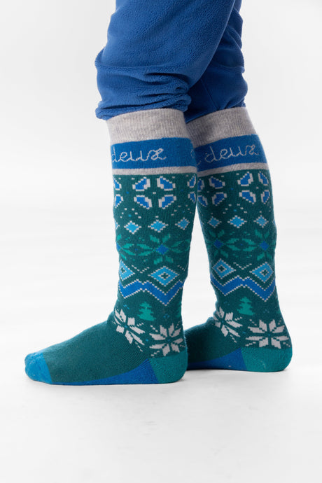 Child wearing dark turquoise Deux par Deux Fair Isle ski socks, legs and feet view