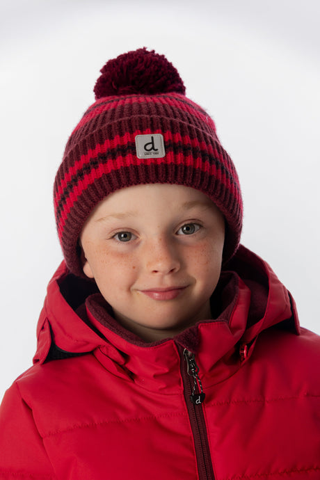 Child wearing the Deux par Deux burgundy striped pompom hat