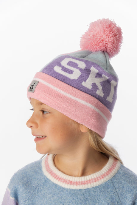 Child wearing the Deux par Deux light blue and light pink SKI band pompom hat