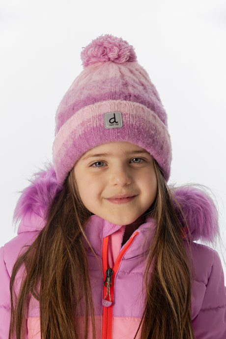 Deux par Deux kids' cable-knit cuffed pompom hat in pinkish violet – worn by a child