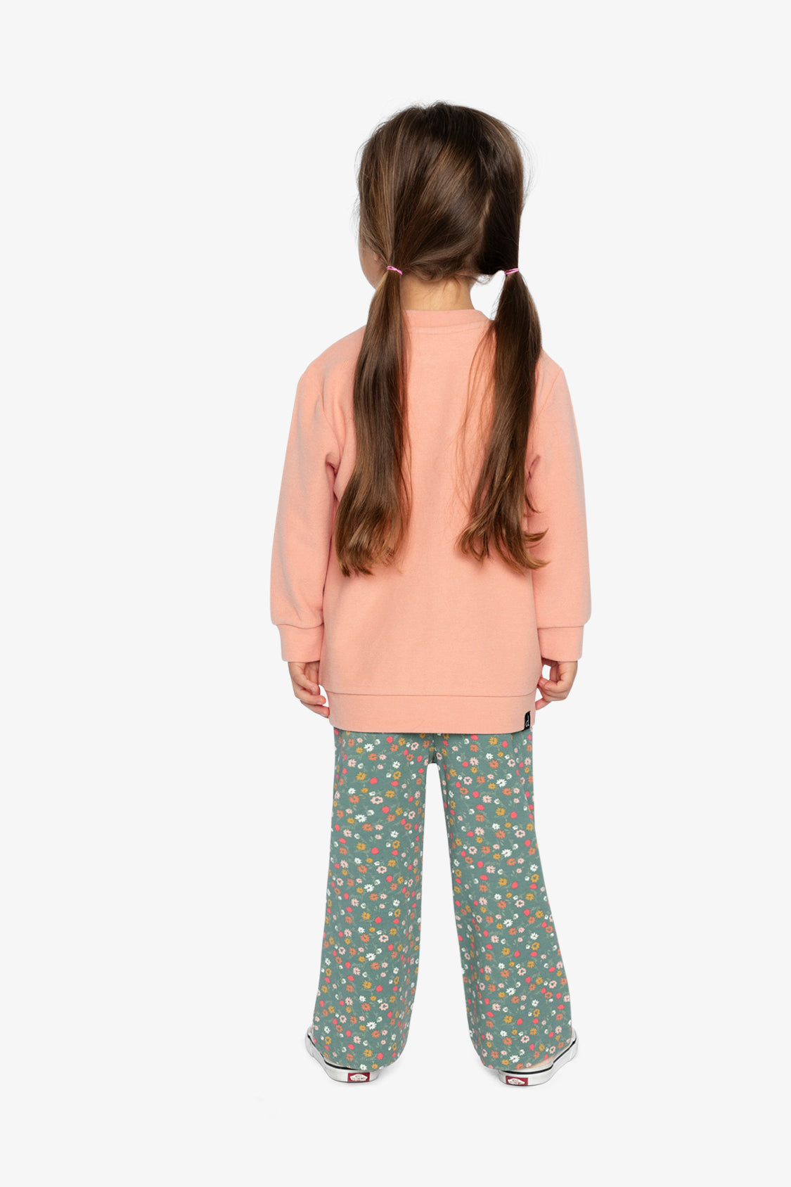 Child wearing the Deux par Deux coral tunic and floral flared leggings, back view