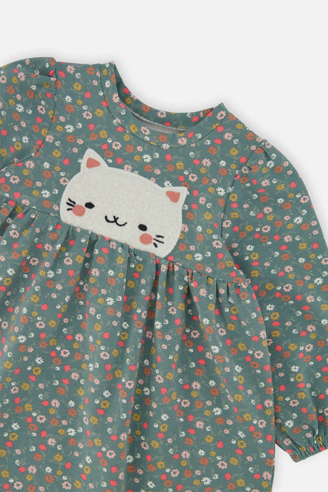 Close-up of the textured cat patch and ditsy floral print on the Deux par Deux green dress
