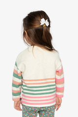Child wearing the off-white striped sweater, back view with a white hair bow