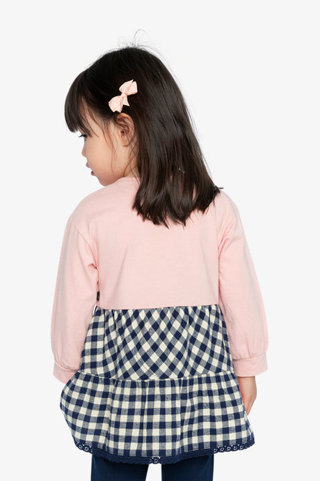 Child wearing the Deux par Deux pink tunic with gingham hem and navy leggings, back view