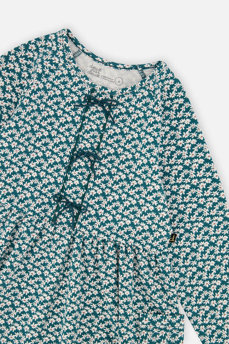 Close-up of the small bows and ditsy floral print on the green organic cotton dress