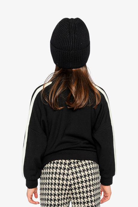 Back view of a child in the black Milano knit jacket with white stripes along both sleeves
