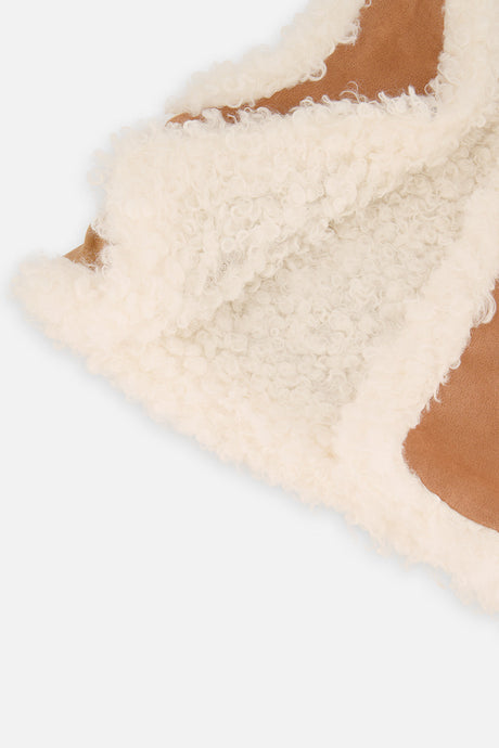 Close-up of cream sherpa edging and tan suede-look panel on the Deux par Deux reversible vest