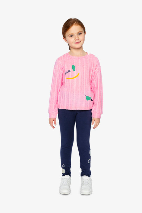 Child wearing the pink knit top with navy leggings, full-length view