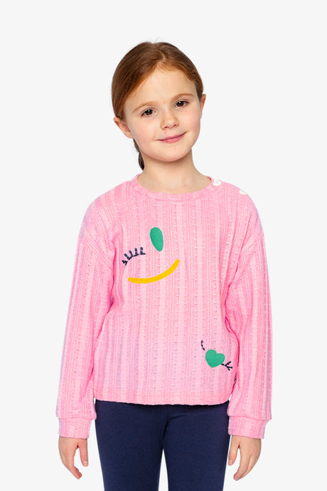 Child wearing the pink knit top, close front view