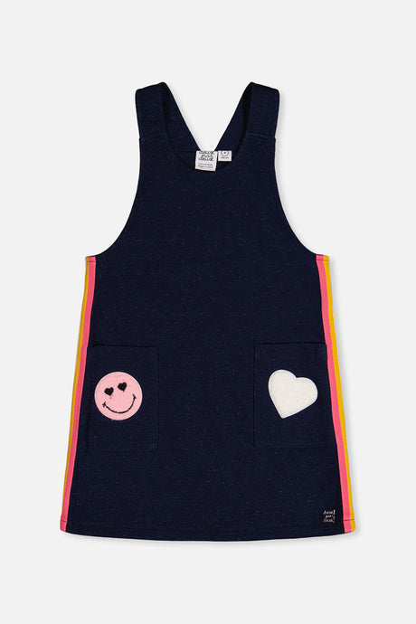 Deux par Deux girls navy overall dress with a smiley patch and heart patch pockets and rainbow side stripes, front flat view