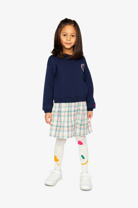Child wearing the Deux par Deux navy sweatshirt dress with a plaid skirt and printed tights