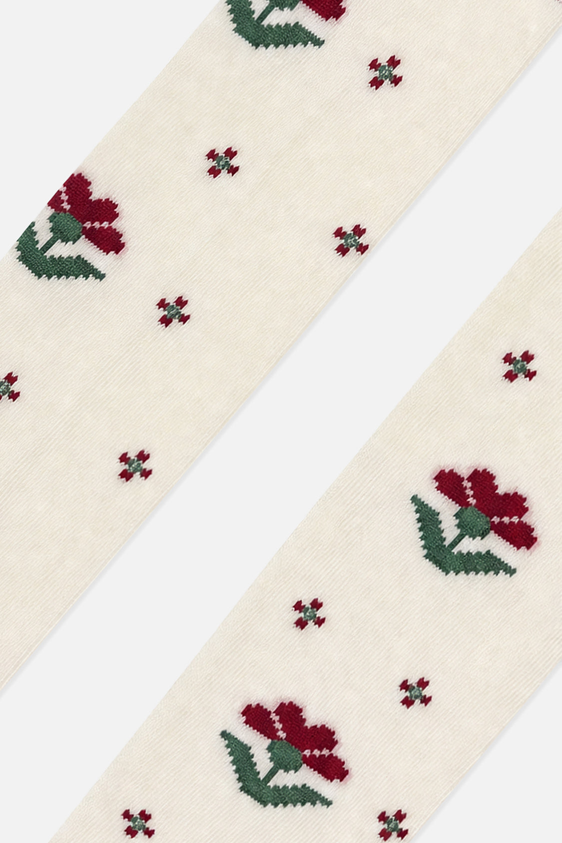 Close-up of burgundy flowers with green leaves on cream knit tights