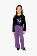 Girl standing in the black Deux par Deux glitter unicorn tee with purple wide-leg pants, full-length front view