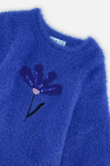 Close-up of the sequin flower on the fuzzy royal blue knit