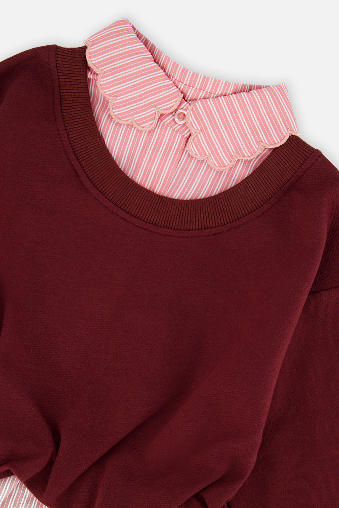 Close-up of the scalloped pink striped collar and the burgundy ribbed neckline on the Deux par Deux sweatshirt