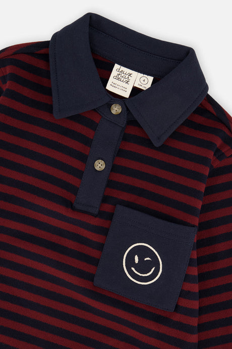 Close-up of the navy polo collar, two buttons and smiley pocket on the striped top