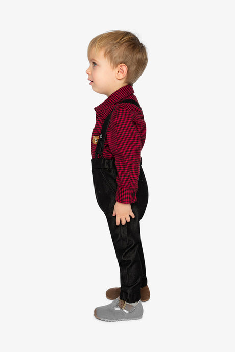 Child wearing the Deux par Deux houndstooth bodysuit and suspender pants, side view