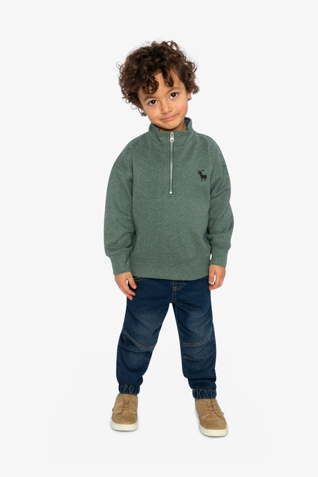 Child wearing the dark green half-zip sweater with dark jeans and tan shoes, full-length view