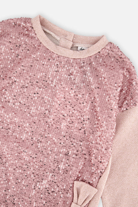 Close-up of the pink sequins and bow on the dusty pink sweatshirt dress