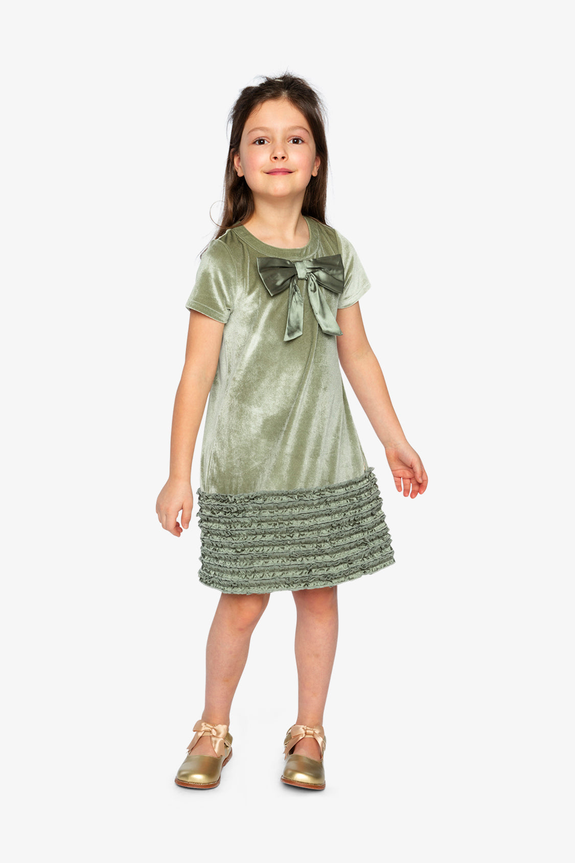 Child wearing the Deux par Deux greyish green velour dress with a bow and gold shoes