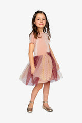 Girl wearing the pink velvet party dress with a gradient star skirt and gold flats