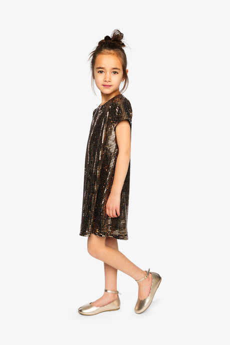 Child wearing the Deux par Deux metallic bronze gold A-line dress, side view