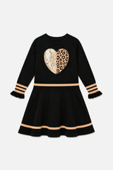 Front view of the black knit dress with beige stripes, ruffle cuffs and a heart on the chest