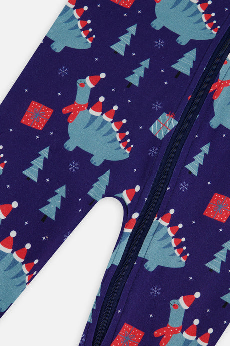Close-up of the dinosaur gift box and pine tree print beside the zipper on the navy baby footed pajama