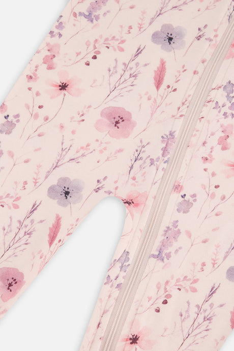 Close-up of the pink and lilac flowers and thin stems on the footed pajama beside the zipper