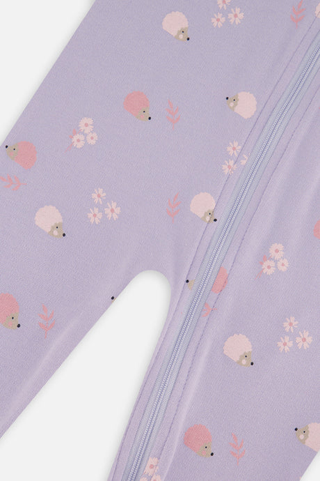 Close-up of the zipper beside pink and cream hedgehogs and small flowers on the lilac fabric