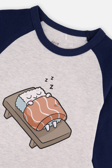 Close-up of the sleeping sushi under a salmon blanket printed on the gray pajama top