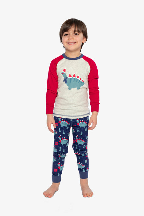 Child wearing the blue dinosaur pajama set standing with red sleeves and navy pants