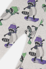 Close-up of raccoons in purple and green hats riding skateboards on the beige pajama fabric
