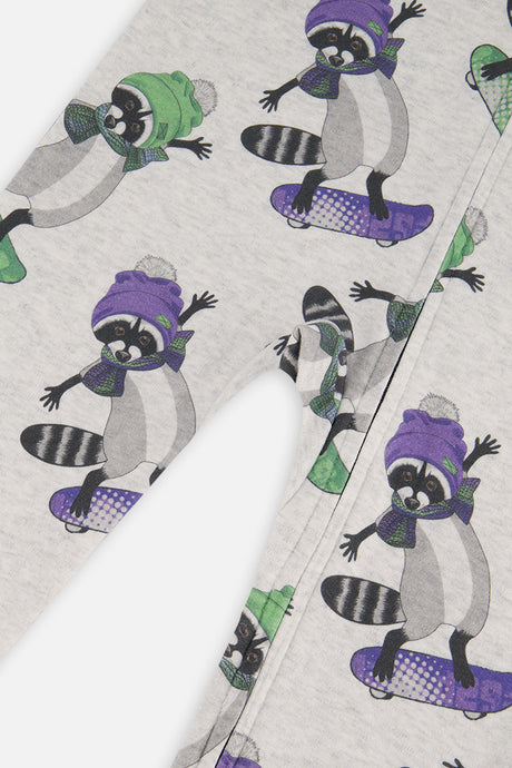 Close-up of raccoons in purple and green hats riding skateboards on the beige pajama fabric