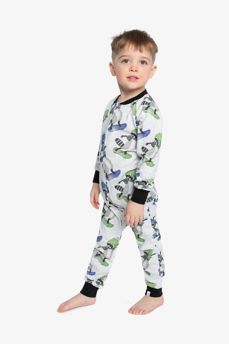 Child wearing the raccoon print one-piece pajama in a three-quarter view showing the skateboard print