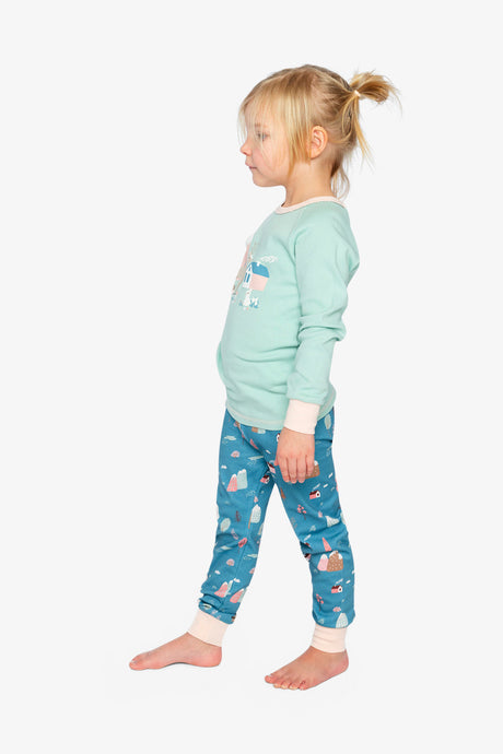 Child wearing the house print pajama set in a side view showing the mint sleeve and pale pink cuff