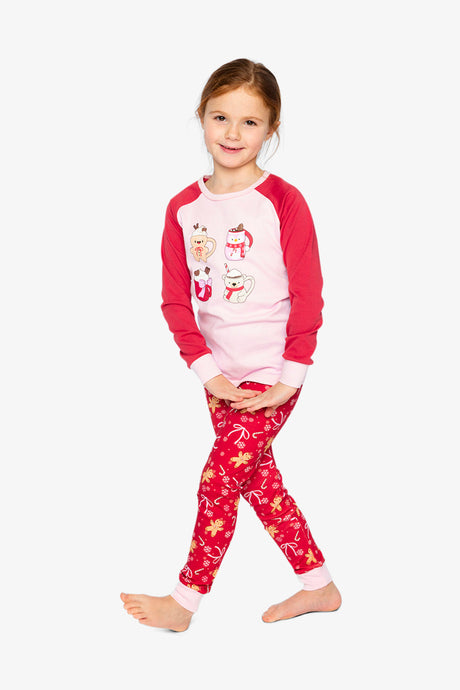 Child wearing the red gingerbread pajama set posing with one foot forward