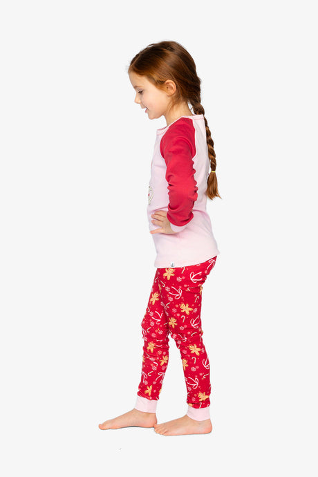 Child wearing the red gingerbread pajama set in side view looking down