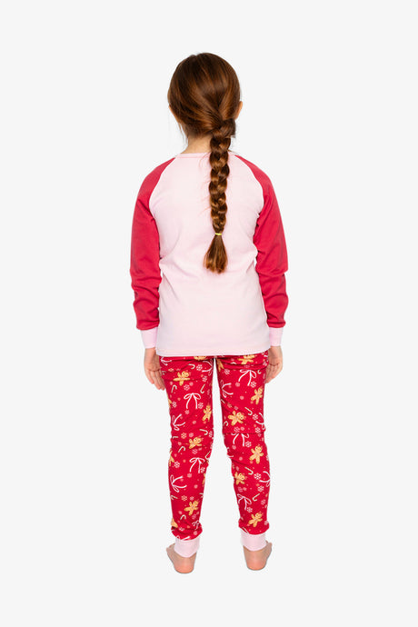 Child wearing the red gingerbread pajama set from behind with a pink back and red sleeves