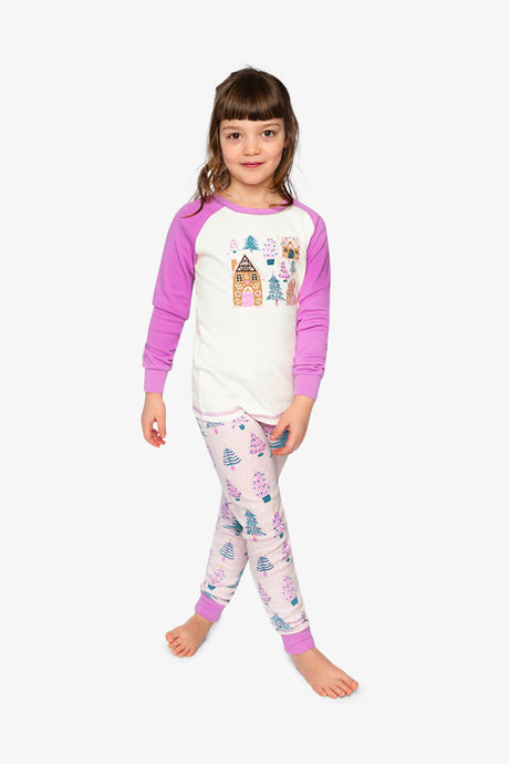 Child wearing the pink tree print pajama set with pink-purple raglan sleeves, front view