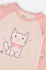 Close-up of the kitten in a polka dot bow on the cream pajama top