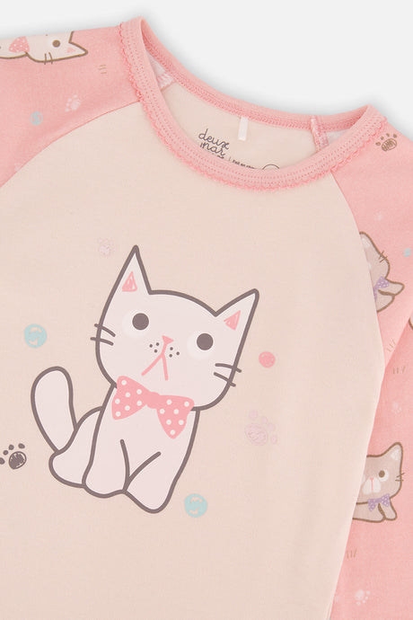 Close-up of the kitten in a polka dot bow on the cream pajama top