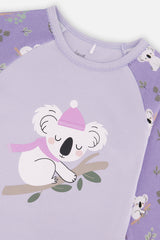 Close-up of the sleeping koala in a pink beanie and scarf on the lilac pajama top with a scalloped neckline