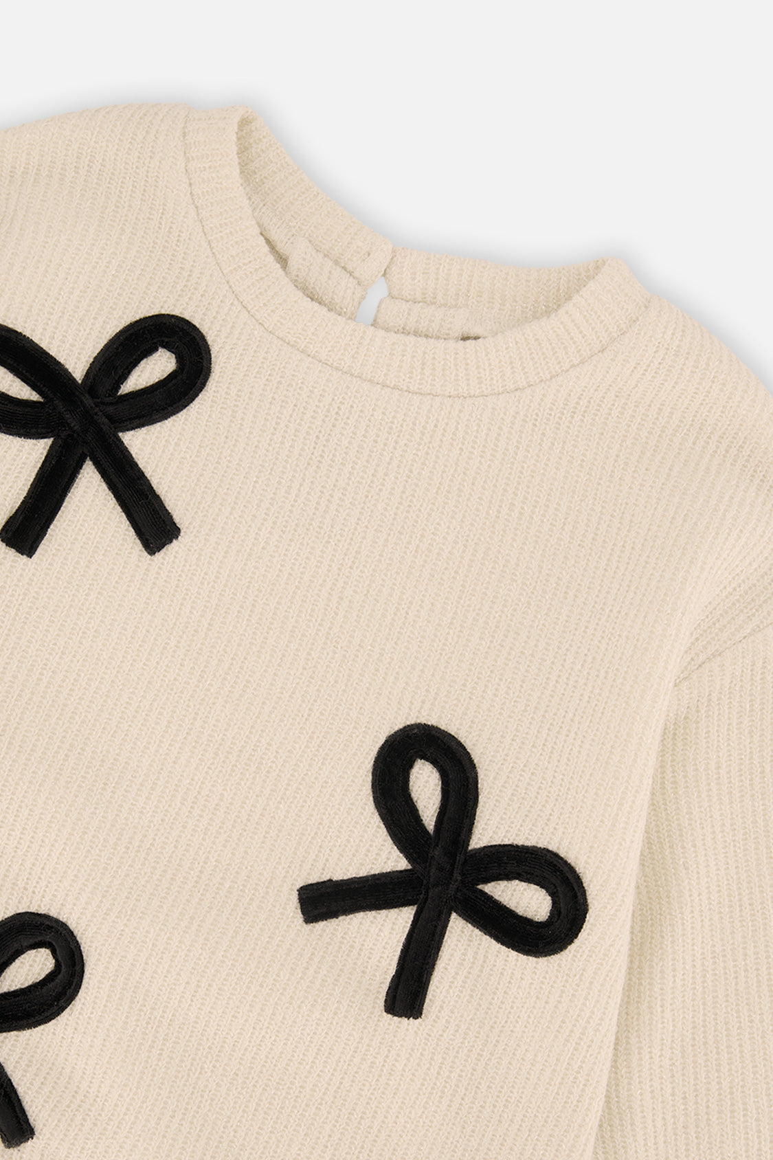 Close-up of the black bow appliqués and ribbed neckline on the beige Deux par Deux sweatshirt