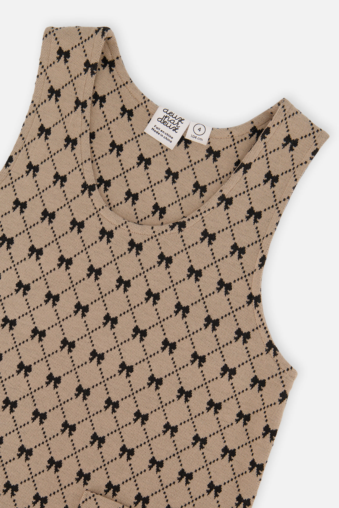Close-up of the neckline and black bow and diamond print on the Deux par Deux jumper dress
