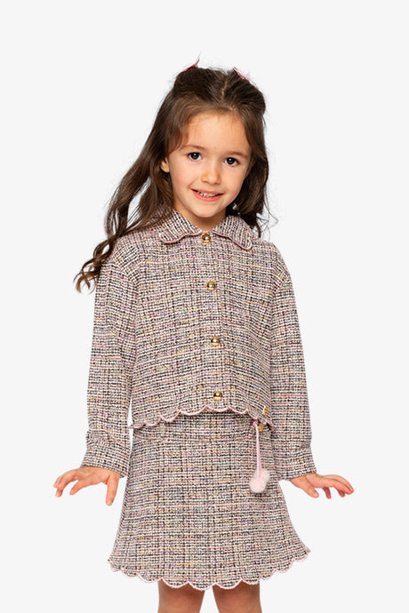Child wearing the pink and black Deux par Deux cropped jacket with a skirt, front view